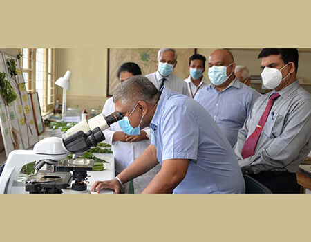 Tea and Rubber Export Promotion State Minister Kanaka Herath visits a lab at the TRI.