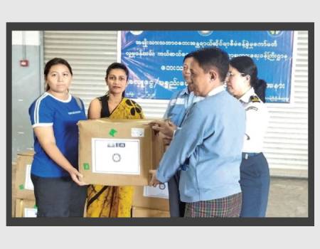 A Sri Lankan Embassy official hands over the consignment of tea to the Director of Natural Disaster Management Centre of Myanmar Than Soe, at the Yangon International Airport.