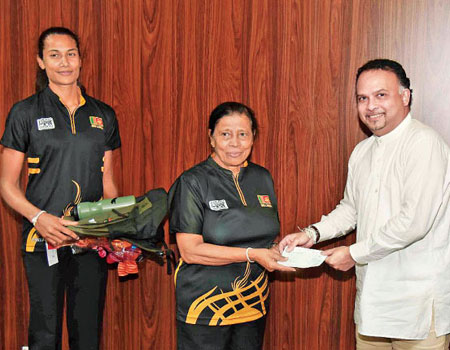 Plantations Industries Minister Naveen Dissanayake handing over the sponsorship cheque to President of the Netball Federation of Sri Lanka Trixy Nanayakkara. Also in the picture is captain of the Sri Lanka Youth netball team Chathurangi Jayasuriya.